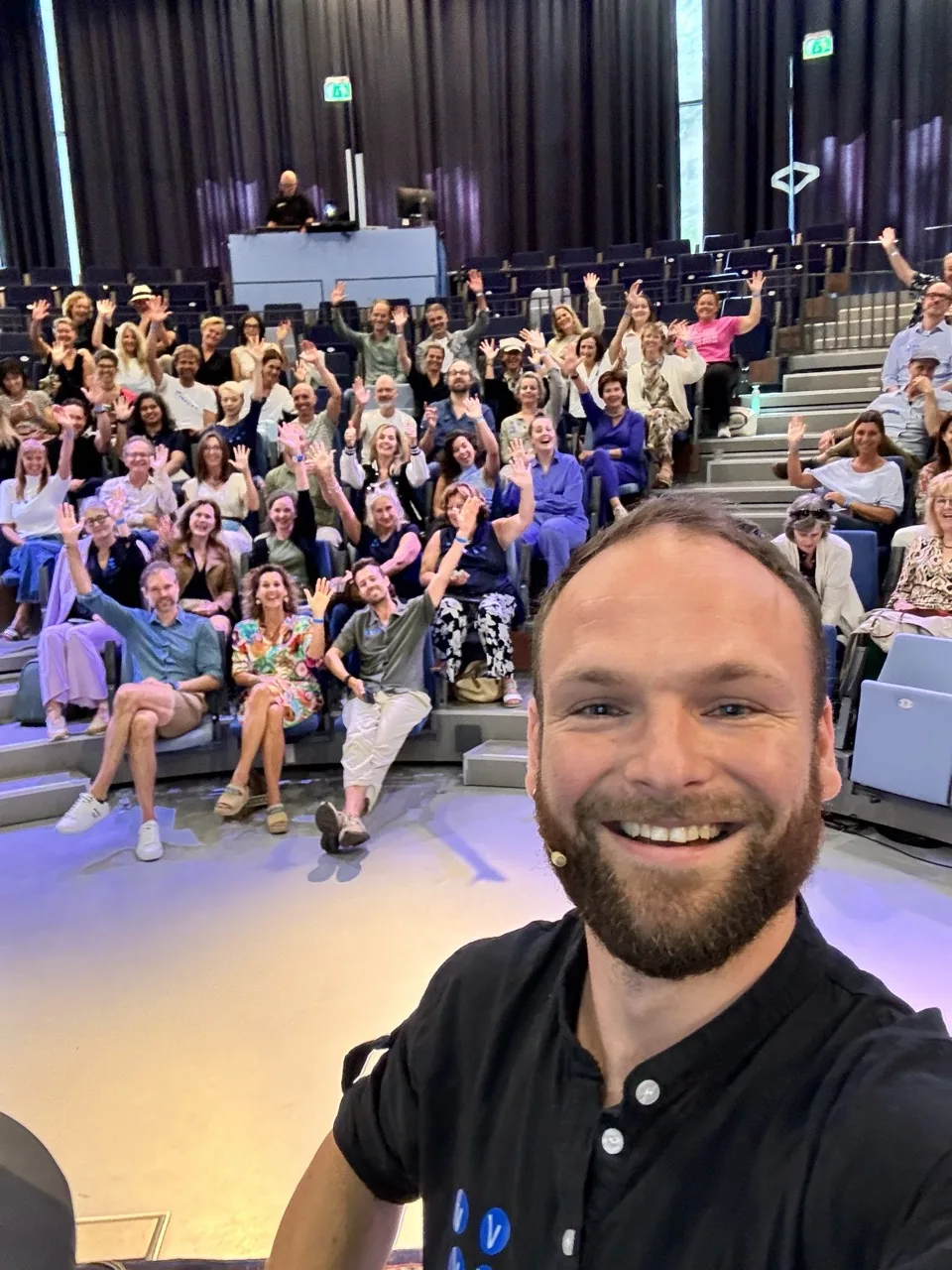 Olaf Lemmens maakt een selfie met een zwaaiende zaal na afloop van een sessie